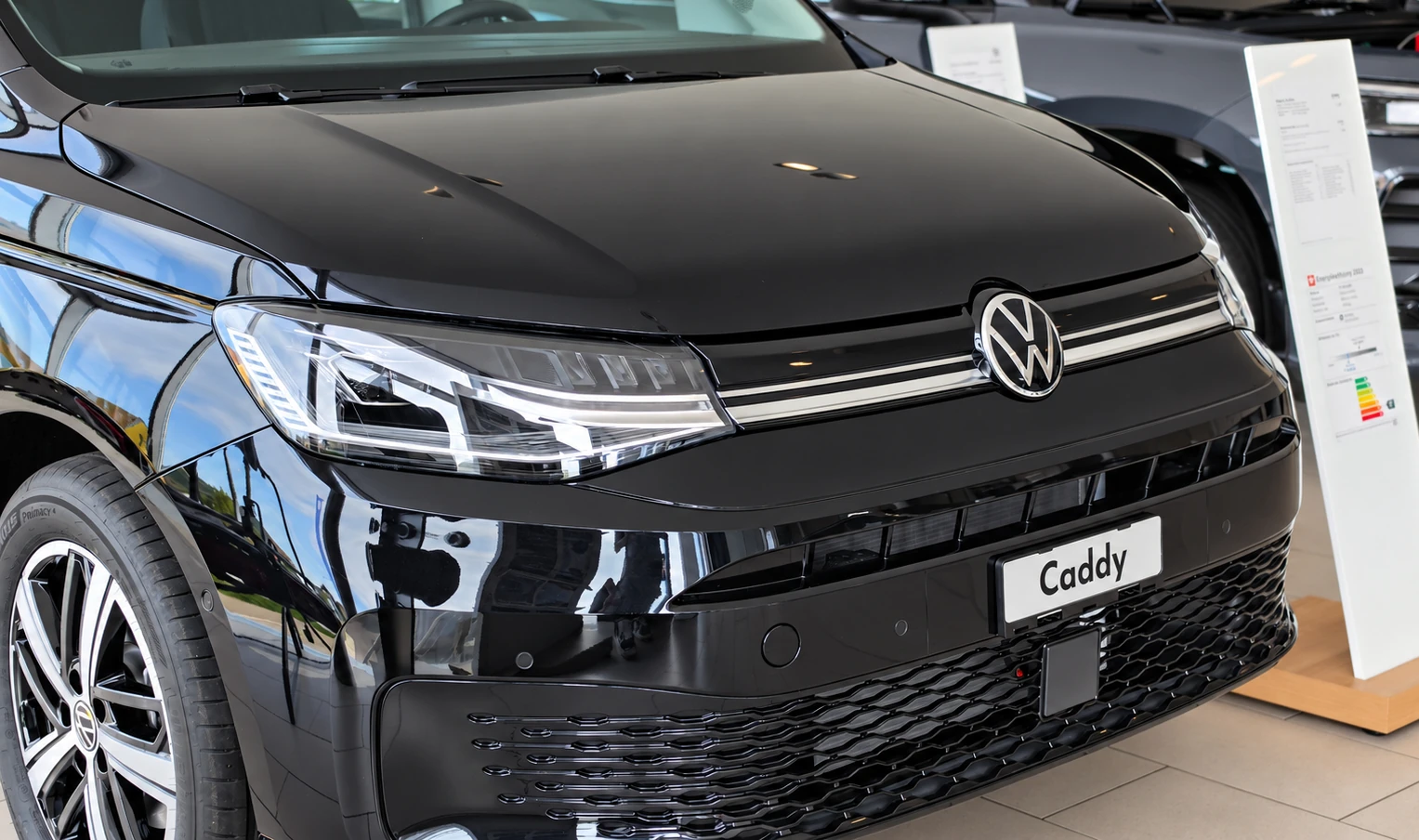 Volkswagen Caddy noir dans le showroom du Garage Rossy SA