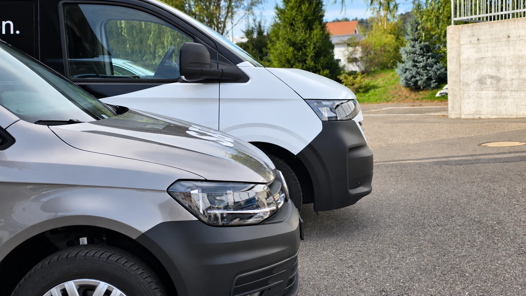 Deux véhicules utilitaires Volkswagen exposés devant le Garage Rossy SA